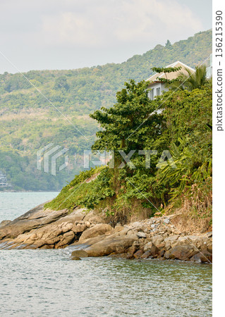 Thailand's coast on a sunny day, villas and hotels among palm trees on a hill, people on a jet ski, a yacht off the coast Thailand's coast on a sunny day, villas and hotels among palm trees on a hill, people on a jet ski, a yacht off the coast 136215390