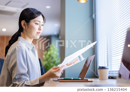 A woman who works while watching materials A woman who works while watching materials 136215404