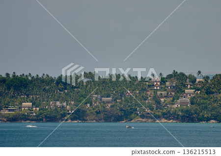 Thailand's coast on a sunny day, villas and hotels among palm trees on a hill, people on a jet ski, a yacht off the coast Thailand's coast on a sunny day, villas and hotels among palm trees on a hill, people on a jet ski, a yacht off the coast 136215513