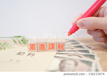 一張用工資和鈔票展示累進稅制和稅負的圖片。 一張用工資和鈔票展示累進稅制和稅負的圖片。 136215674