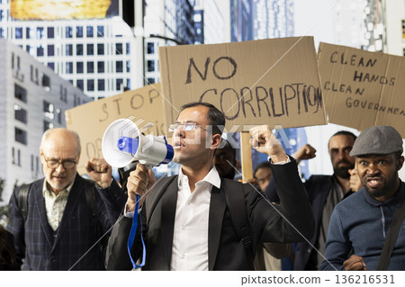 Large crowd of diverse protesters taking action against corrupt government, posters with messages like stop corruption, freedom and equal rights during a non-violent demonstration. 136216531