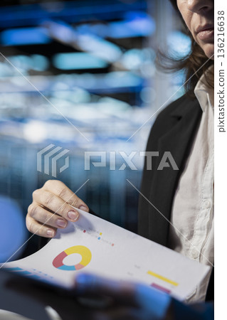 Storage rackmounts inspection, report files and specialist in server farm reading benchmarks, close up. Checkup, documentation and system administrator in data center analyzing machines parts papers 136216638