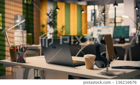 Empty office for business work environment with modern furniture, bright open space with stylish decorations and stationery at desk setup. Windows provide natural light for productivity. Empty office for business work environment with modern furniture, bright open space with stylish decorations and stationery at desk setup. Windows provide natural light for productivity. 136216676