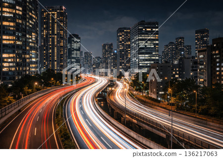 夜幕降臨，城市高速公路和摩天大樓上延伸出一道道燈光軌跡。 136217063