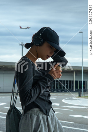 A woman drinking coffee at the airport. Photo courtesy of Kansai International Airport (KIX). 136217485