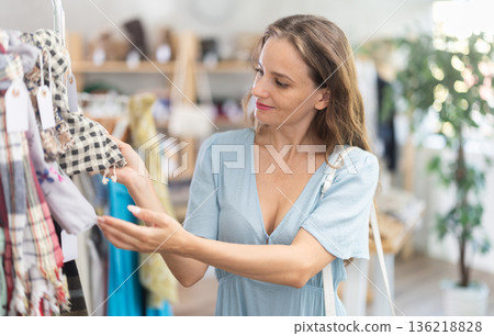 Woman choosing a scarf in a store Woman choosing a scarf in a store 136218828