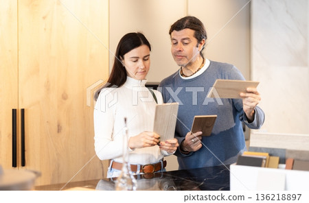 Married couple choosing samples for kitchen decoration 136218897