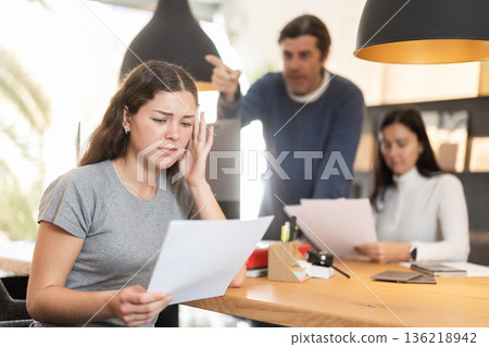 Upset female manager with papers in front of clients Upset female manager with papers in front of clients 136218942