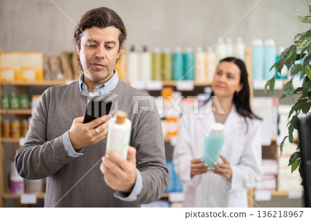 Man buyer scans shampoo qr code with woman pharmacist 136218967