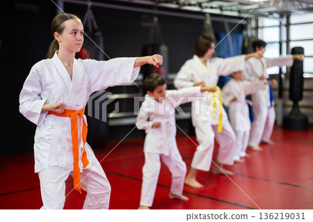 Group of children and teenagers practice karate 136219031