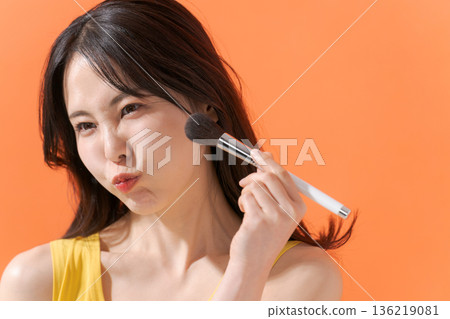 一位笑容燦爛的女子手持化妝刷 136219081