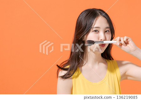 Smiling woman holding makeup brushes Smiling woman holding makeup brushes 136219085