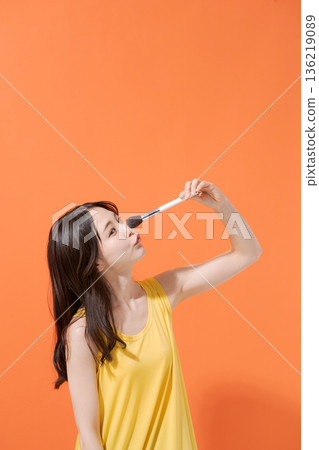 Smiling woman holding makeup brushes 136219089