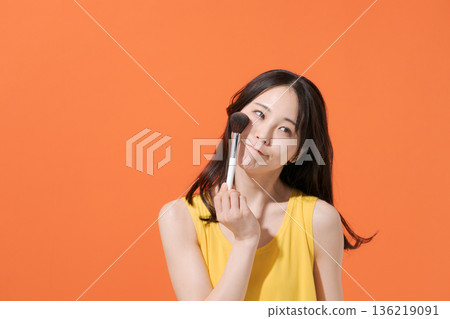 一位微笑的女子手持化妝刷 一位微笑的女子手持化妝刷 136219091