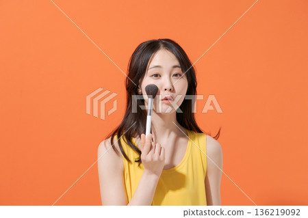 一位微笑的女子手持化妝刷 136219092