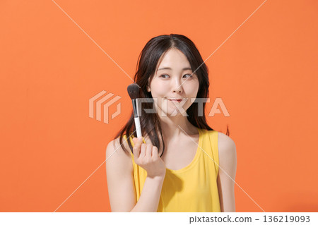 Smiling woman holding makeup brushes Smiling woman holding makeup brushes 136219093