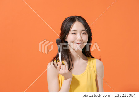 Smiling woman holding makeup brushes Smiling woman holding makeup brushes 136219094