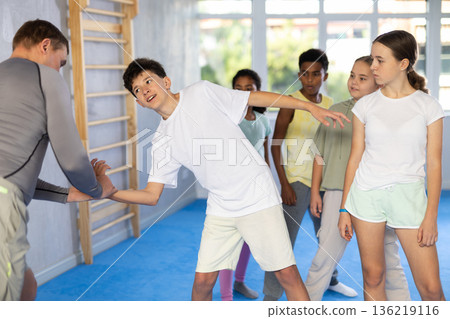 Coach and boy training self-defense techniques 136219116