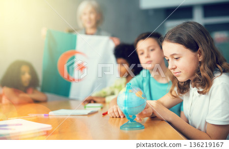 Female teacher showing algerian flag to kids in geography class Female teacher showing algerian flag to kids in geography class 136219167