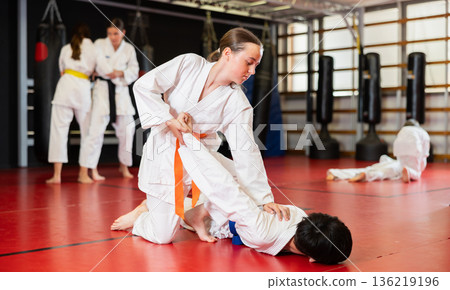 Teenage boy and girl training judo in pairs 136219196