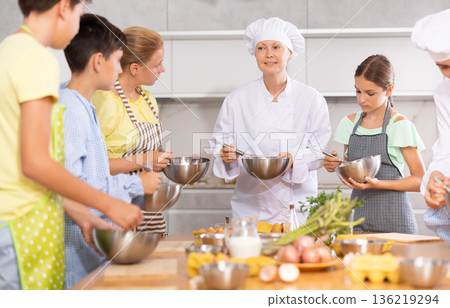 Amiable female chef running culinary courses for preteen children 136219294