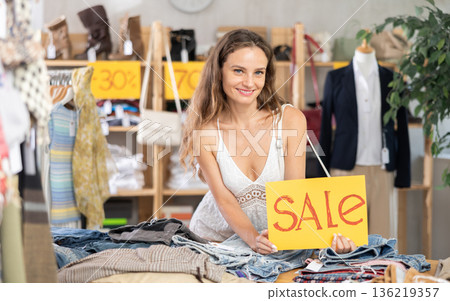 Young woman holding a sign that says sale Young woman holding a sign that says sale 136219357