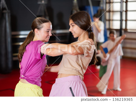 Two teenage girls practice self-defense in pairs 136219365