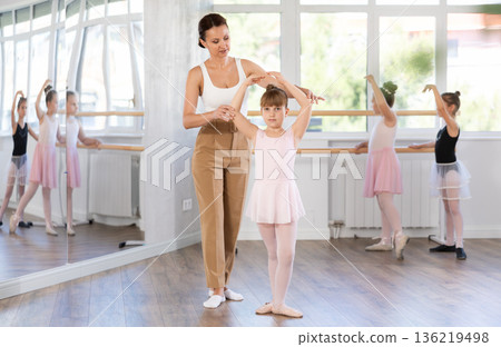 Woman teacher corrects movement of girl dancer 136219498