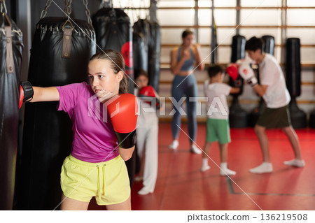 Teen girl training with punching bag 136219508