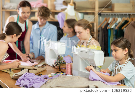 Preteen girl stitching at machine during sewing class for children Preteen girl stitching at machine during sewing class for children 136219523