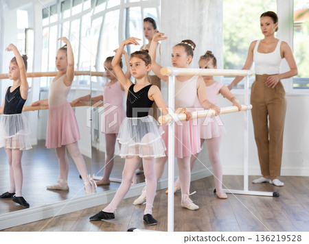 Girls in ballet class perform Batman with correction of female mentor Girls in ballet class perform Batman with correction of female mentor 136219528