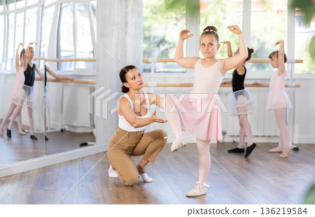 Woman teacher corrects movement of girl dancer 136219584