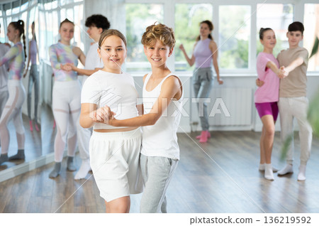 Group of positive teenagers learning to dance tango in dance studio 136219592
