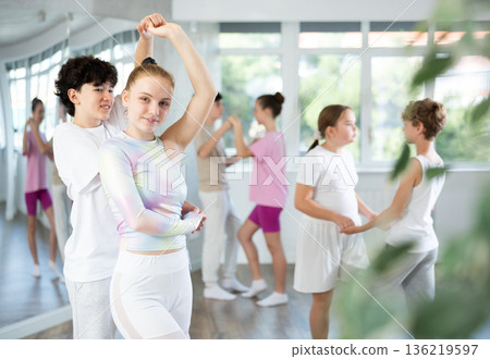 Group of teenagers, girls and boys, dance a slow ballroom dance in choreography studio 136219597