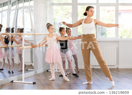 Teacher dancer performing pirouette in front of class 136219609