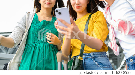 朋友們在旅途中低頭看手機。照片由關西國際機場（KIX）提供。 136220553