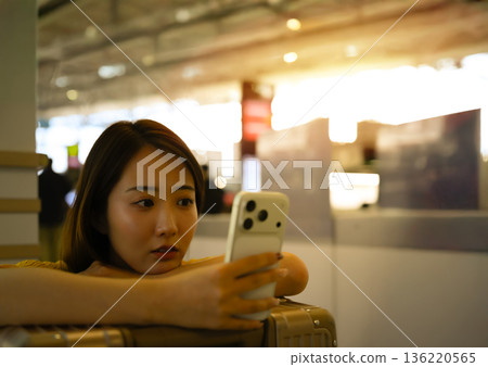 一名女子在機場使用智慧型手機。照片由關西國際機場（KIX）提供。 136220565