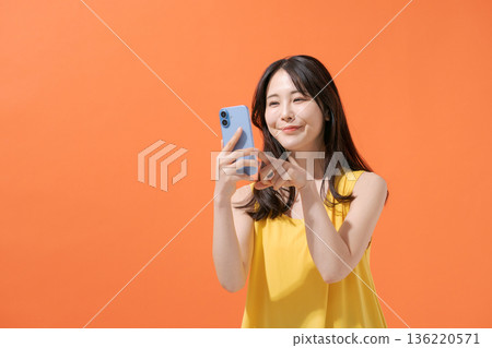 拿著智能手機的微笑的婦女 136220571