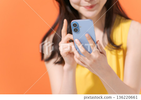 拿著智能手機的微笑的婦女 136220661