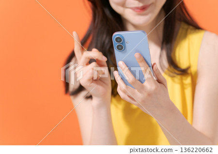 拿著智能手機的微笑的婦女 136220662