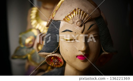 serene Bali dancer ceramic bust featuring closed eyes, bright lips, and gold embellishments. Ideal decorative sculpture for home, temple, or gallery displays, emphasizing art, culture, and craft 136221369
