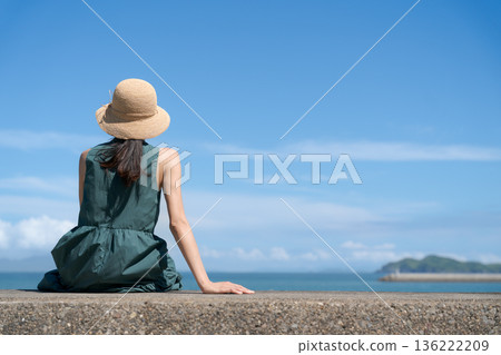 A woman sitting in a breakwater A woman sitting in a breakwater 136222209