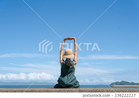A woman sitting in a breakwater 136222217