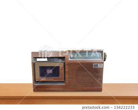 A vintage-style retro portable radio sits on a wooden table against a white background. 136222233
