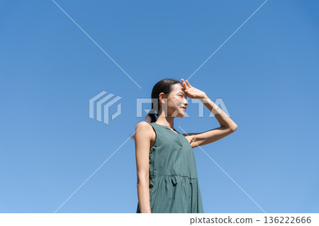 A woman dazzled under the blue sky A woman dazzled under the blue sky 136222666