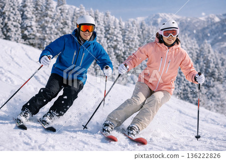 Two skiers skiing down a snowy mountain 207 136222826