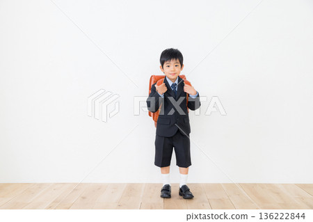 一個穿著西裝、背著書包的男孩 136222844
