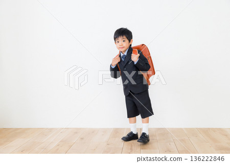 一個穿著西裝、背著書包的男孩 一個穿著西裝、背著書包的男孩 136222846