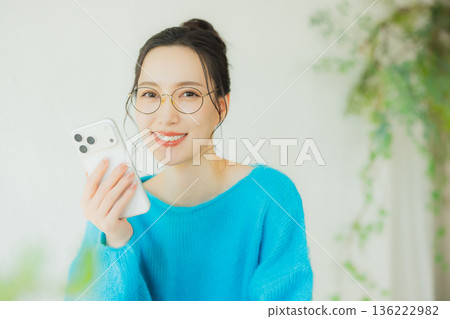 A woman watching a smartphone A woman watching a smartphone 136222982
