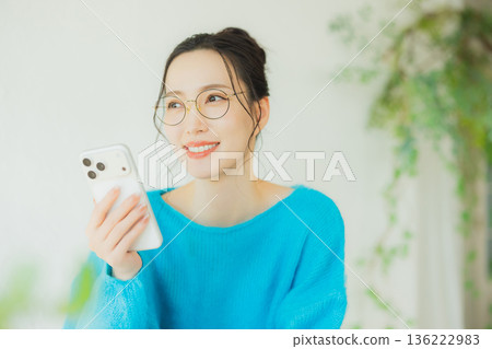 A woman watching a smartphone A woman watching a smartphone 136222983